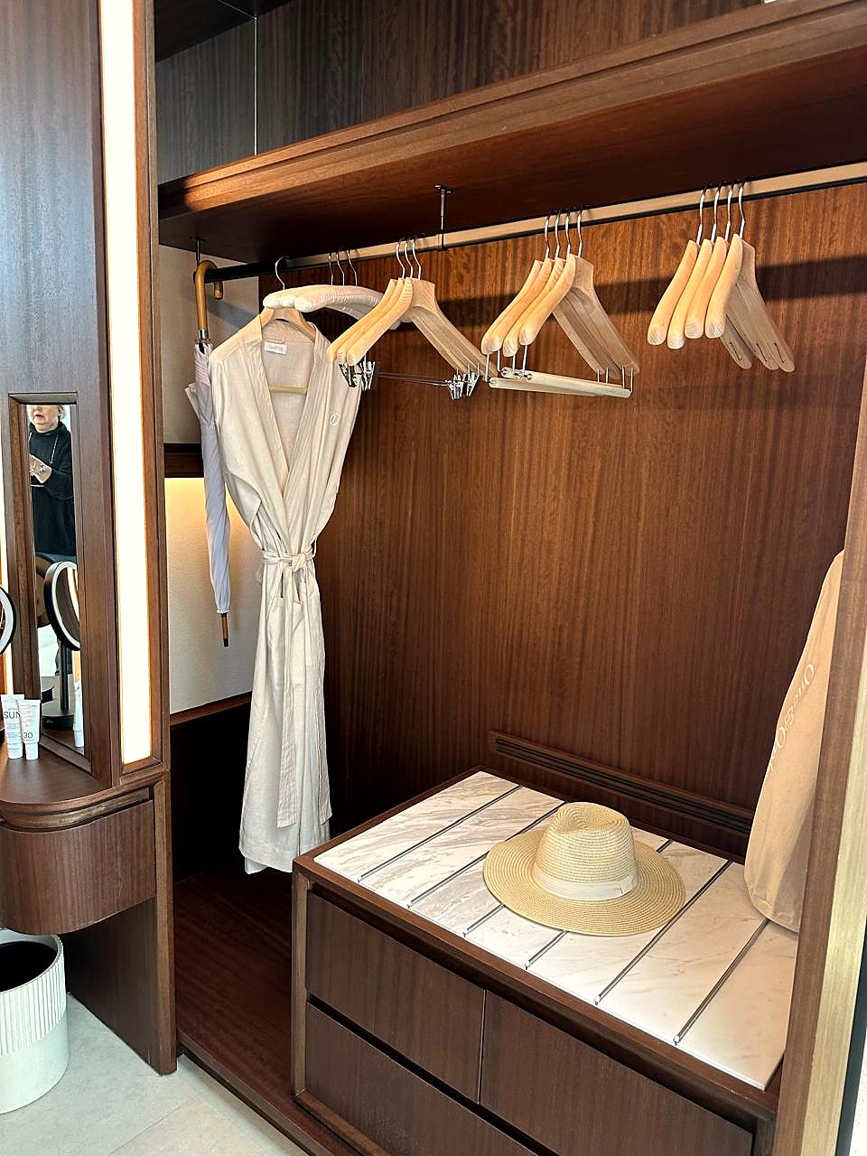 Wardrobe with bathrobe, wooden hangers and guest amenities, dressed to standard.